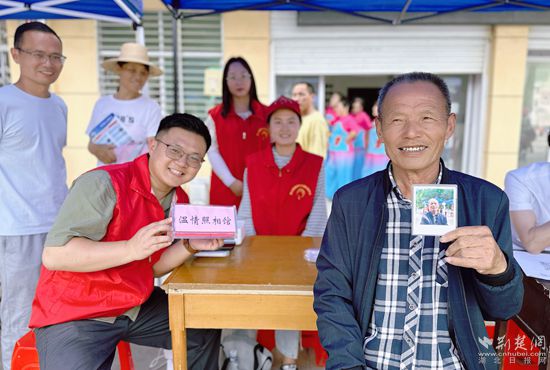 “溫情照相館”攤位上，前來(lái)照相的老人與志愿者開(kāi)心地合影留念_副本.jpg